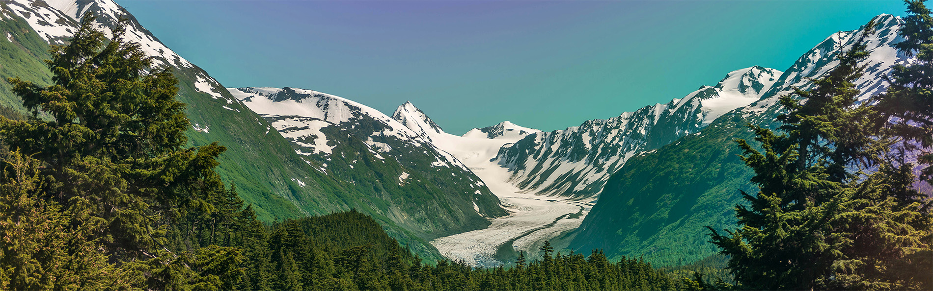 alaska blue lake with mountains and greenery, things you'll see on an alaska cruise